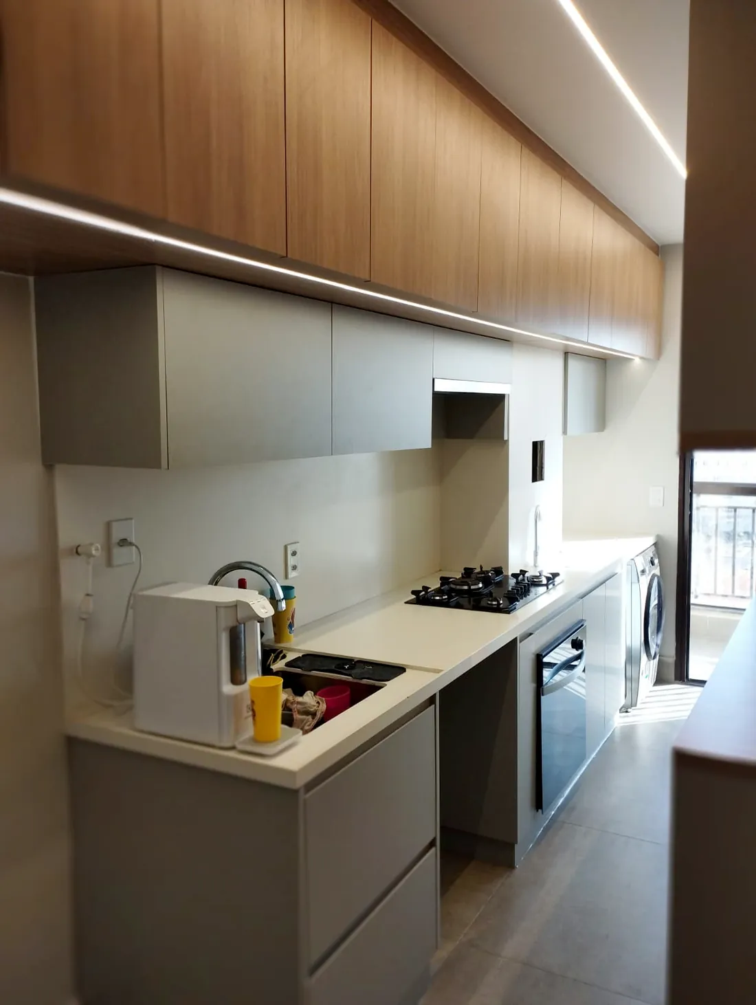 Cozinha planejada em MDF amadeirado e cinza com fita de LED embutida, em Brasília DF
